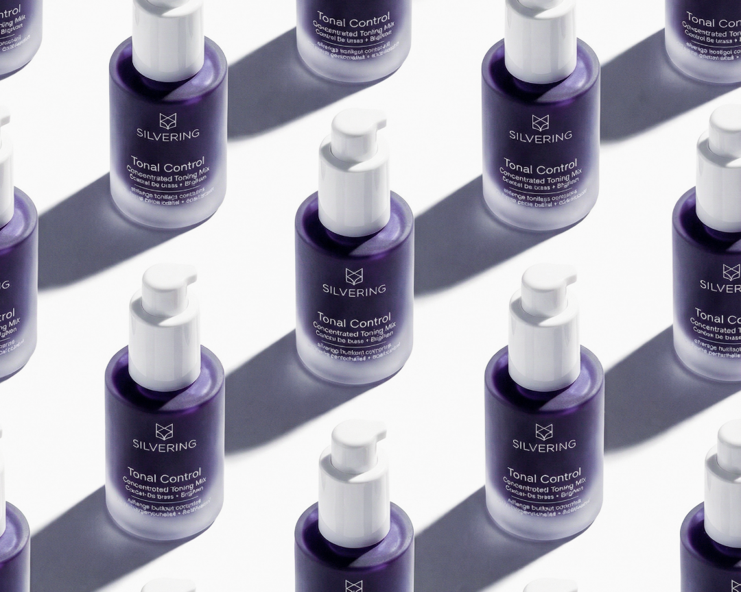 Multiple bottles of Silvering Total Control serum arranged in a pattern on a reflective surface.